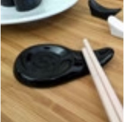 Black spoon and chopstick rest, designed to keep utensils organized and clean, sold by the case.