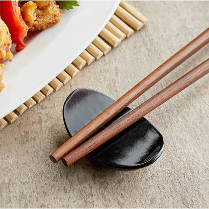 Set of 12 black bowl-shaped chopstick rests, sleek and functional holders to keep chopsticks clean and organized during meals.



