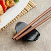 Set of 12 black bowl-shaped chopstick rests, sleek and functional holders to keep chopsticks clean and organized during meals.



